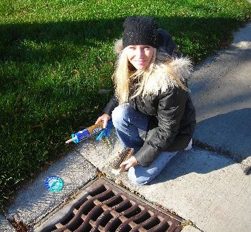 Carey Protecting the Environment - Carey Torrice applies markers to storm drains in a Clinton Township community